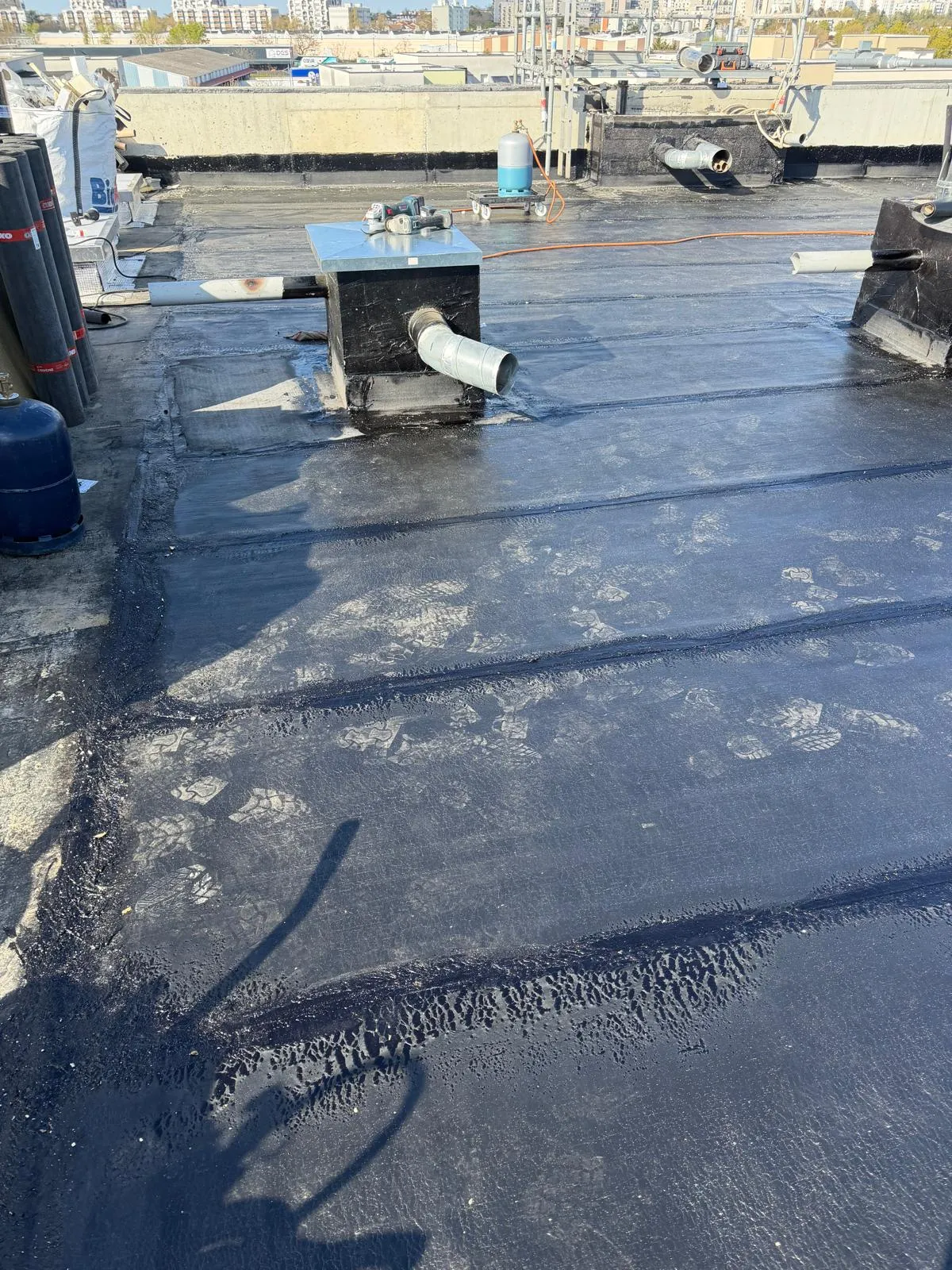 Membrane d'étanchéité bitumineuse soudée autour d'une souche de ventilation sur toiture-terrasse par Muller Toiture, couvreur dans l'Est lyonnais